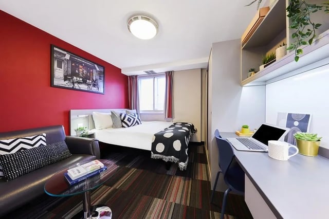 Sofa bed desk with laptop plants bedding and artwork bedroom at The Moor in Sheffield Student Accommodation
