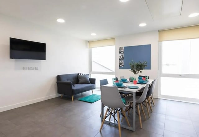 Sofa dining table chairs and TV living room at Aparto Arbury Court in Kingston Upon Thames Student Accommodation