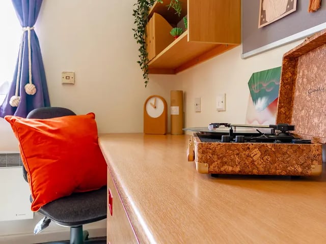 Desk with record player orange pillow study area at Yugo Park Court in Lincoln Student Accommodation
