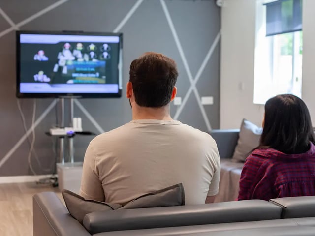 Two people watching TV living room. at Yugo Park Court in Lincoln Student Accommodation