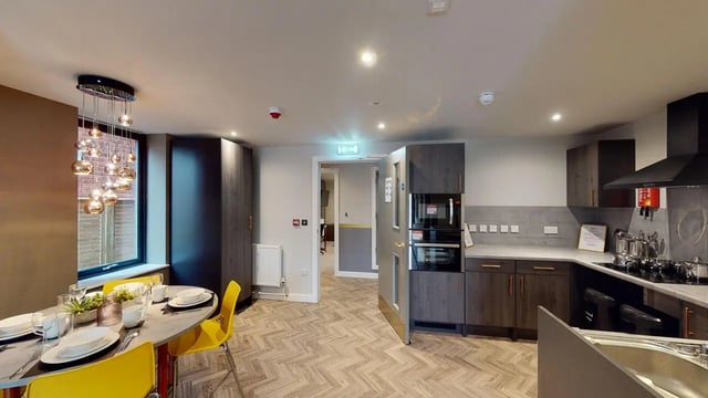 Dining table yellow chairs kitchen appliances kitchen at Astra House in London Student Accommodation