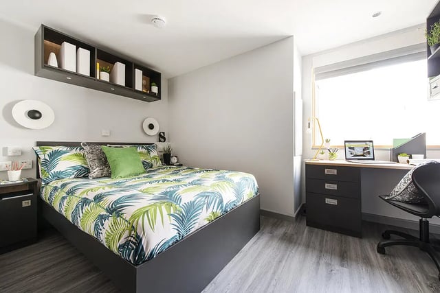 Bed with tropical print linens and desk with laptop bedroom at Yugo Therese House in London Student Accommodation