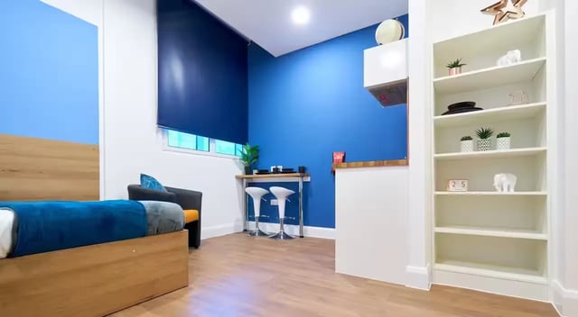 Bed blue blanket chairs table stools study area at St Leonard's House in Lancaster Student Accommodation