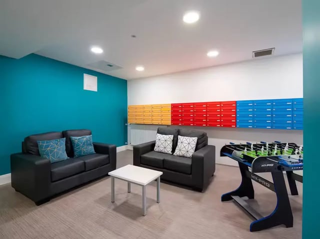 Two sofas foosball table mailboxes common area living room at St Leonard's House in Lancaster Student Accommodation