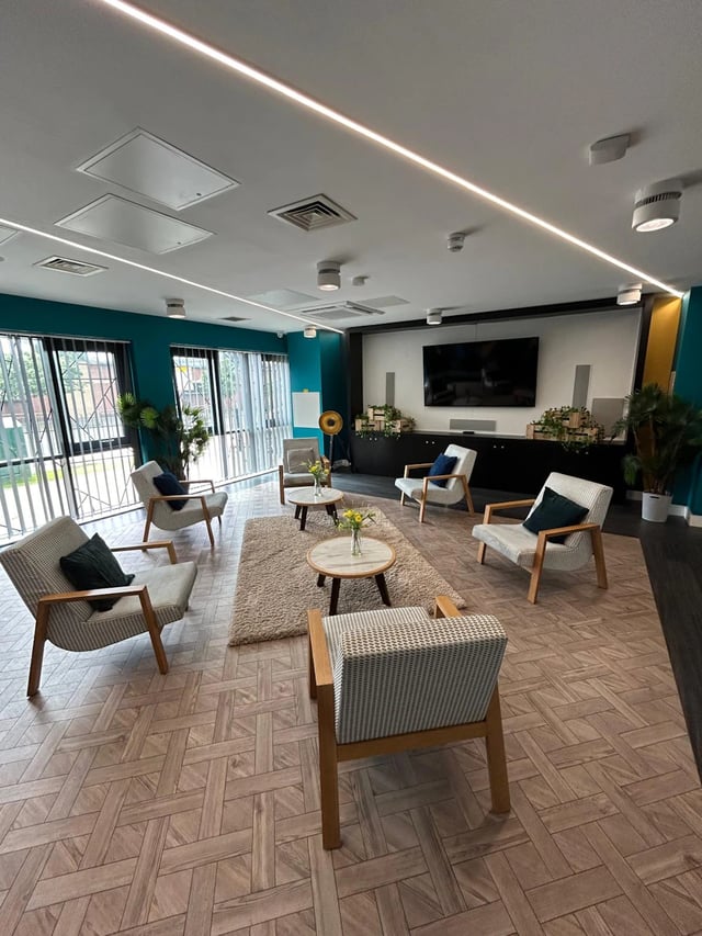 Seating area with chairs tables and television lounge at Opto Newcastle in Newcastle Upon Tyne Student Accommodation
