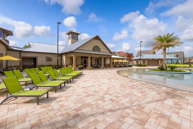 Green lounge chairs pool and building exterior at The Retreat West in Orlando Student Accommodation