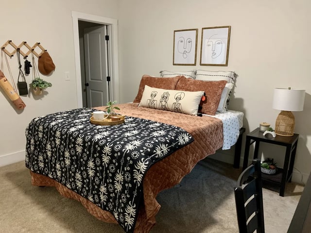 Bed with patterned throw and side table Bedroom at The Retreat West in Orlando Student Accommodation