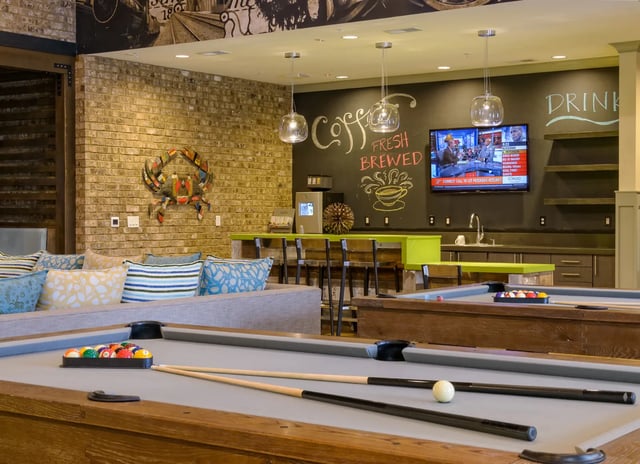 Pool tables couch and coffee bar living room at The Retreat West in Orlando Student Accommodation