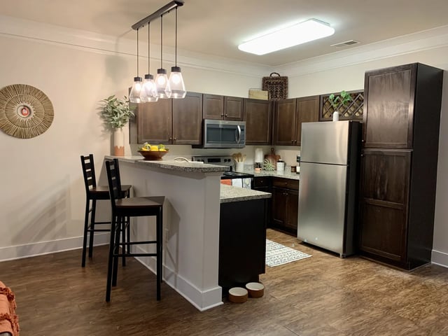 Kitchen with island bar two stools refrigerator kitchen kitchen at The Retreat West in Orlando Student Accommodation