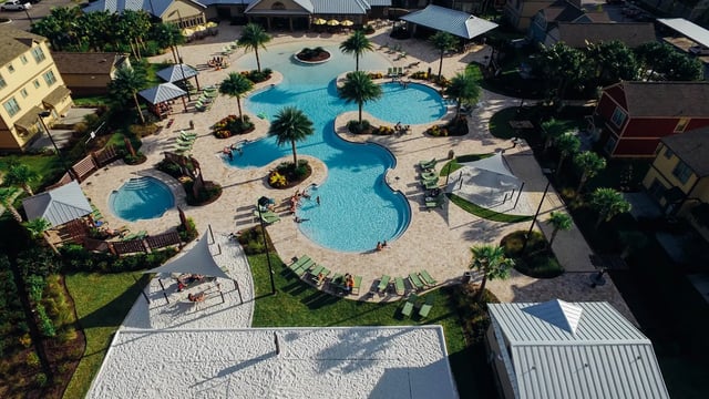 Resort pools lounge chairs and palm trees exterior at The Retreat West in Orlando Student Accommodation