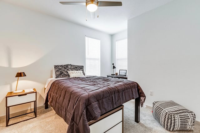 Bed nightstand desk lamp ottoman bedroom at Vale East in Orlando Student Accommodation