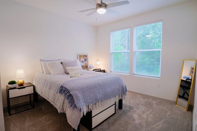 Bed with pillows and blankets nightstand mirror bedroom at Vale East in Orlando Student Accommodation