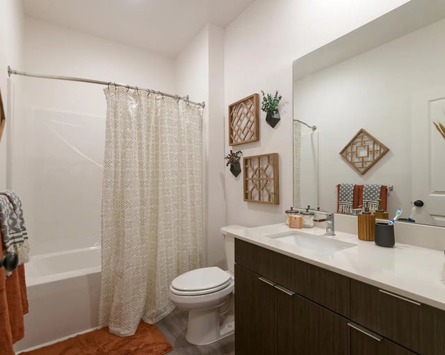Toilet bathtub patterned shower curtain vanity bathroom at The Retreat East in Orlando Student Accommodation