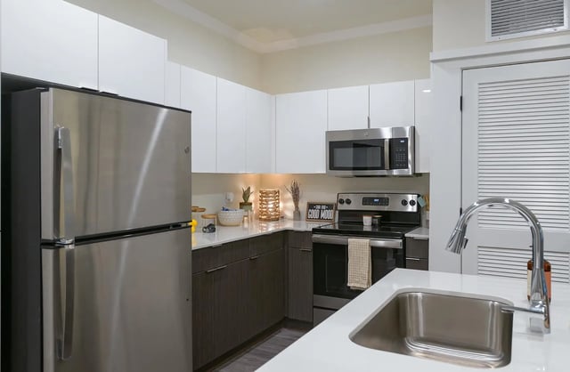 Stainless steel refrigerator microwave stove sink kitchen at The Retreat East in Orlando Student Accommodation
