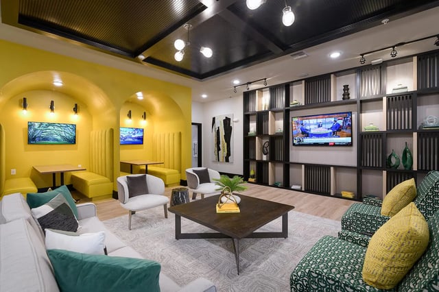 Modern lounge with yellow booths and seating area living room at The Retreat East in Orlando Student Accommodation