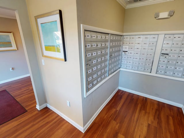 Mailboxes on wall with artwork and wood floor exterior at Seminole Flatts in Tallahassee Student Accommodation