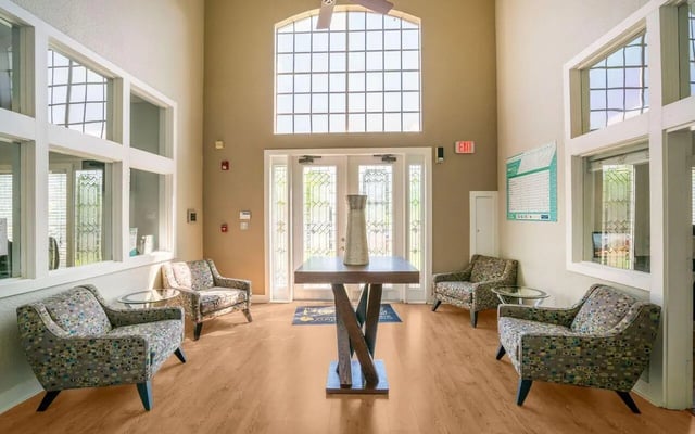 Seating area with patterned chairs and central table lobby area at Pointe at Central in Orlando Student Accommodation