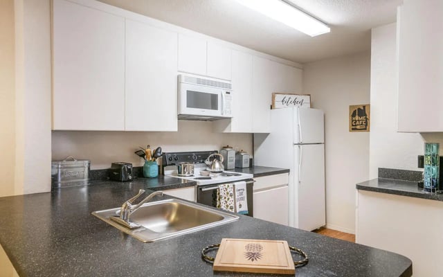 Kitchen with sink stove refrigerator and cabinets Kitchen at Pointe at Central in Orlando Student Accommodation