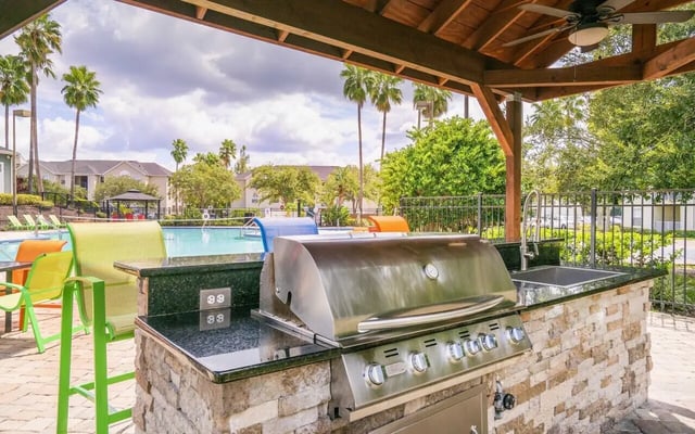 Outdoor kitchen with grill sink and pool area exterior at Pointe at Central in Orlando Student Accommodation