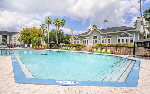 Swimming pool with lounge chairs and building exterior at Pointe at Central in Orlando Student Accommodation