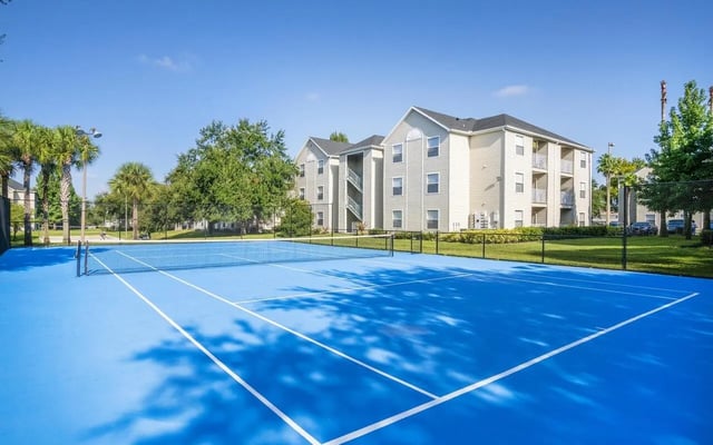 Blue tennis court with apartment buildings exterior at Pointe at Central in Orlando Student Accommodation