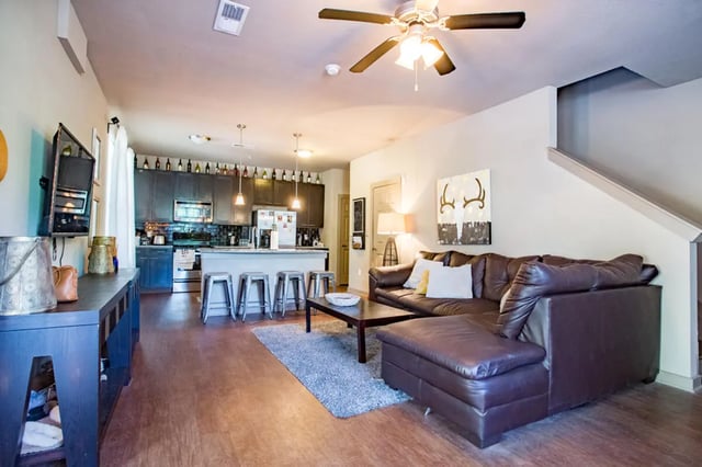 Leather sofa kitchen island bar stools living area at CollegePlace - Horizon in Tallahassee Student Accommodation