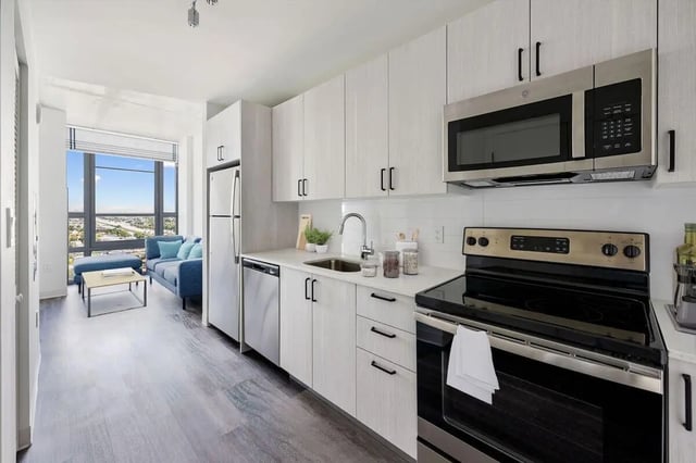 Modern kitchen with blue sofa and city view kitchen at Terrazul in Miami Student Accommodation