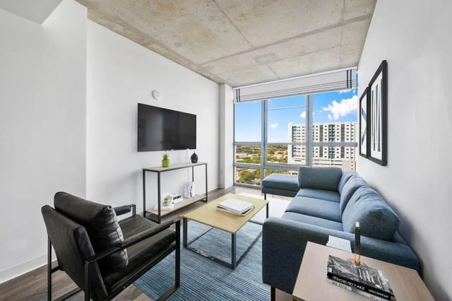 Blue sectional couch coffee table television living room at Terrazul in Miami Student Accommodation