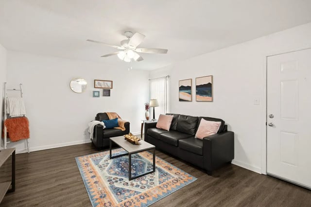 Black sofa chair rug coffee table living room at Villa Reanna in Tallahassee Student Accommodation
