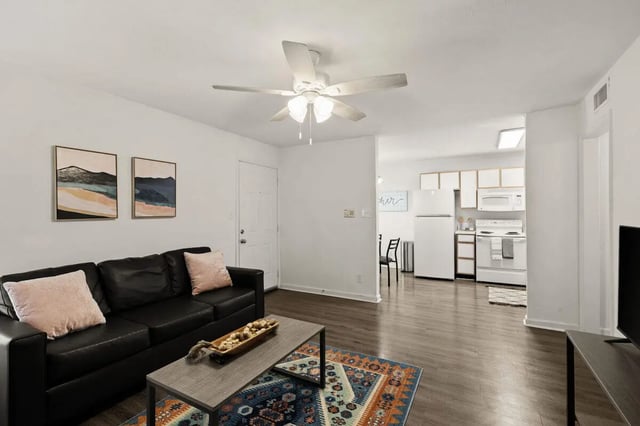 Black sofa coffee table rug kitchen living room at Villa Reanna in Tallahassee Student Accommodation