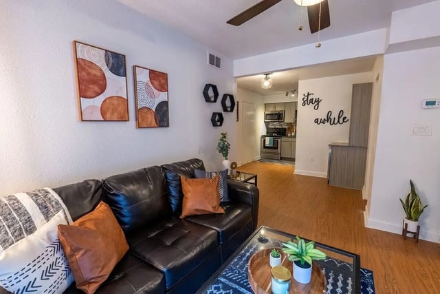 Dark leather couch with pillows and art living room at Vertex Tallahassee in Tallahassee Student Accommodation