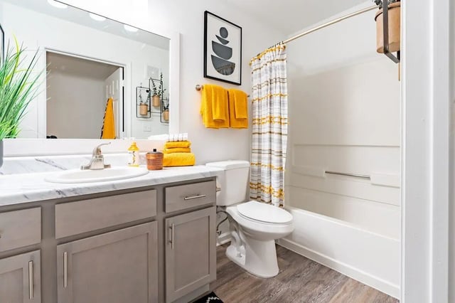 Modern bathroom with grey vanity and yellow towels bathroom at The Annex at Campus West in Tallahassee Student Accommodation
