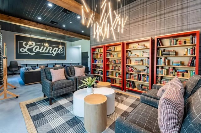 Chairs sofas bookshelves lounge area living room at The Annex at Campus West in Tallahassee Student Accommodation