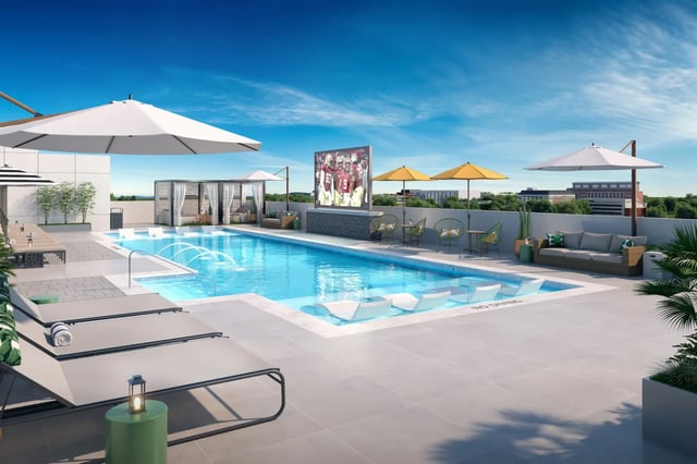 Pool with lounge chairs umbrellas and outdoor TV area at The Tribe in Tallahassee Student Accommodation