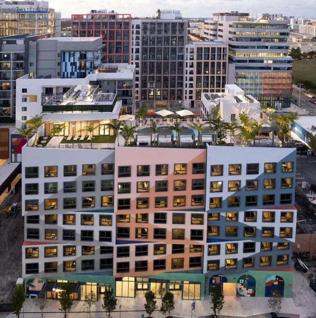 Colorful apartment building with rooftop pool and palm trees exterior at I5 WYNWOOD in Miami Student Accommodation