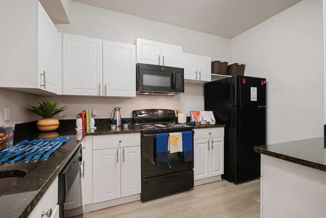 Modern white cabinets black appliances coffee maker kitchen at The Verge Orlando in Orlando Student Accommodation
