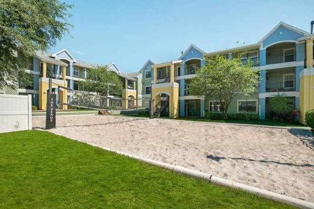 Beach volleyball court with apartment buildings exterior at The Verge Orlando in Orlando Student Accommodation