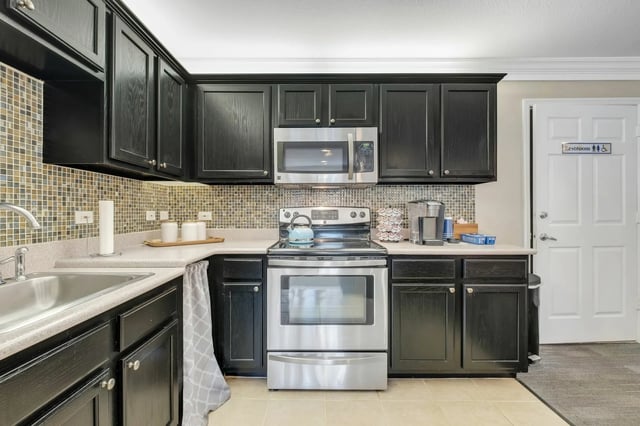 Black cabinets microwave oven stove sink kitchen at The Landing at Appleyard in Tallahassee Student Accommodation