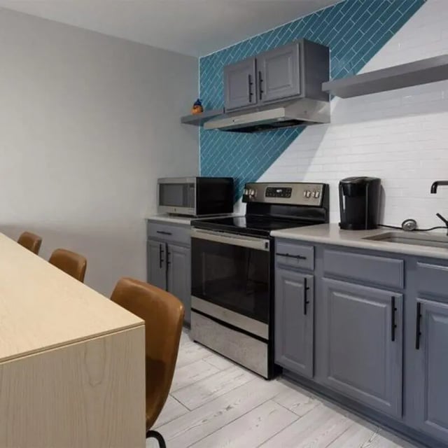 Kitchen with gray cabinets stove microwave and dining counter kitchen at Windsor Hall in Gainesville Student Accommodation