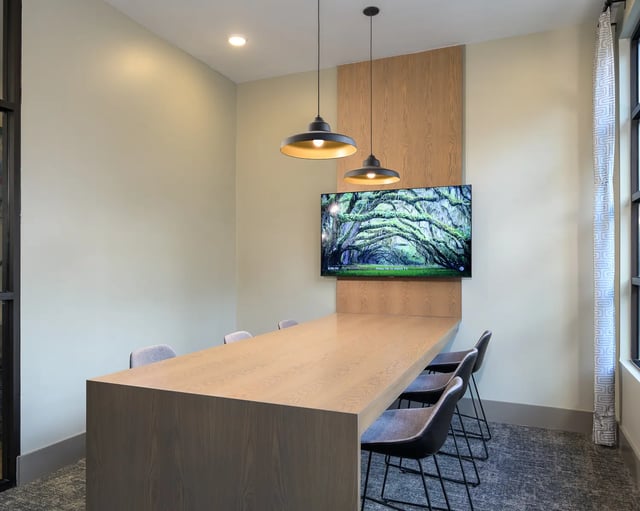 Long table with chairs and TV study area at The Metropolitan Tallahassee in Tallahassee Student Accommodation