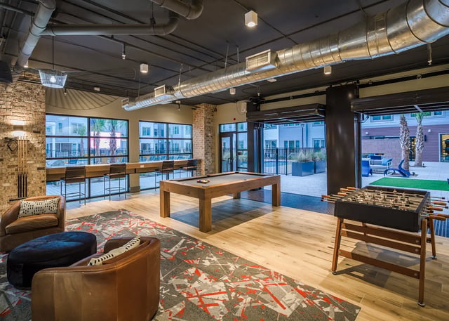 Pool table foosball chairs and bar seating living room at The Metropolitan Tallahassee in Tallahassee Student Accommodation