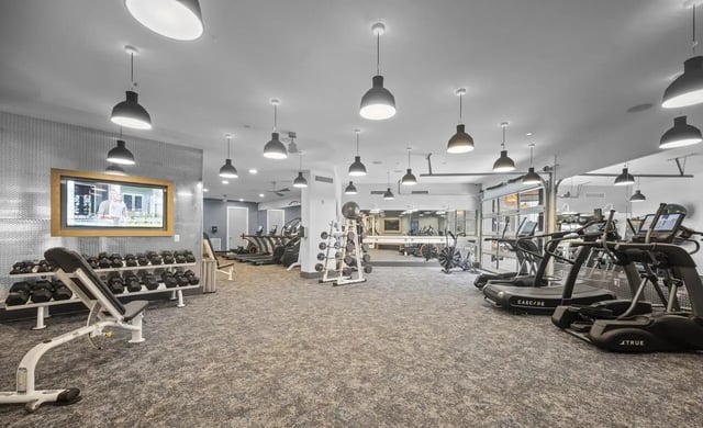 Treadmills weights bench and TVs gym area at Stadium House Gainesville in Gainesville Student Accommodation
