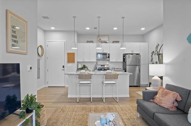 Kitchen island with bar stools and appliances kitchen at Stadium House Gainesville in Gainesville Student Accommodation