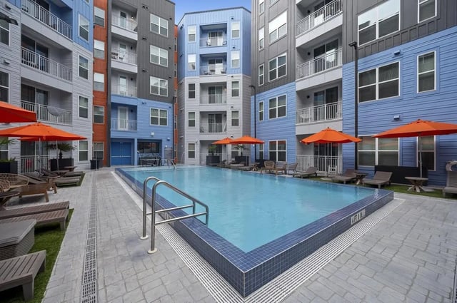Apartment buildings pool lounge chairs umbrellas exterior at Stadium House Gainesville in Gainesville Student Accommodation
