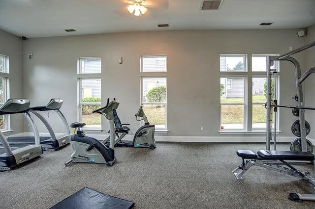 Treadmills stationary bikes weight bench gym area at The Premier Townhomes at 1694 in Tallahassee Student Accommodation