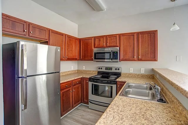 Stainless steel refrigerator stove microwave kitchen area at The Premier Townhomes at 1694 in Tallahassee Student Accommodation