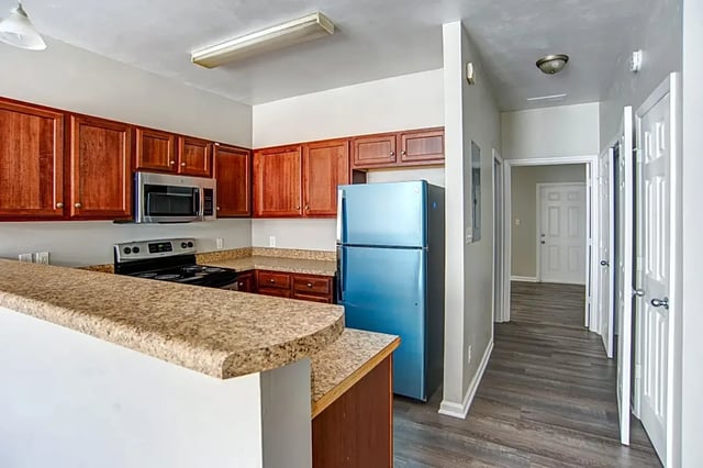 Blue refrigerator microwave oven kitchen counter kitchen at The Premier Townhomes at 1694 in Tallahassee Student Accommodation