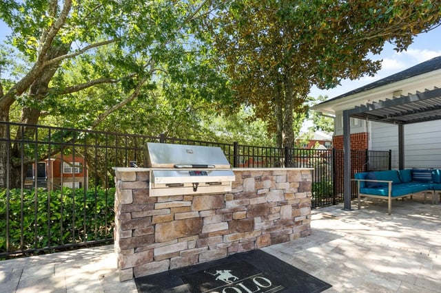 Built-in grill stone counter blue couches outdoor area at Polo Club Tallahassee in Tallahassee Student Accommodation