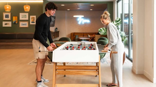 Foosball table with people playing game room at NOVA Tallahassee in Tallahassee Student Accommodation
