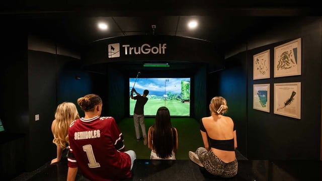Four friends watching golf simulator playing area at NOVA Tallahassee in Tallahassee Student Accommodation